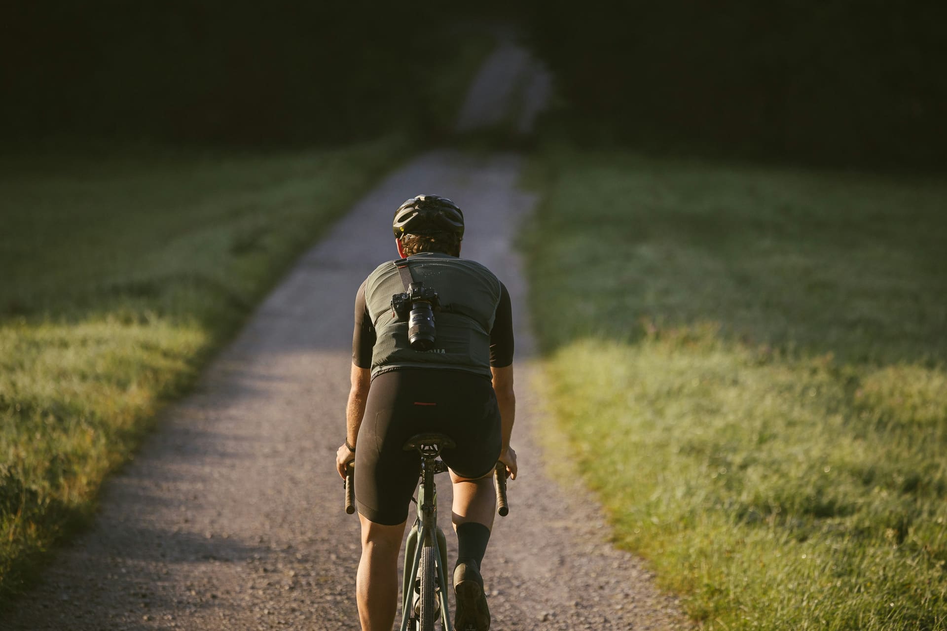Rowerzysta na szutrowej drodze o zachodzie słońca, z dala od zasięgu